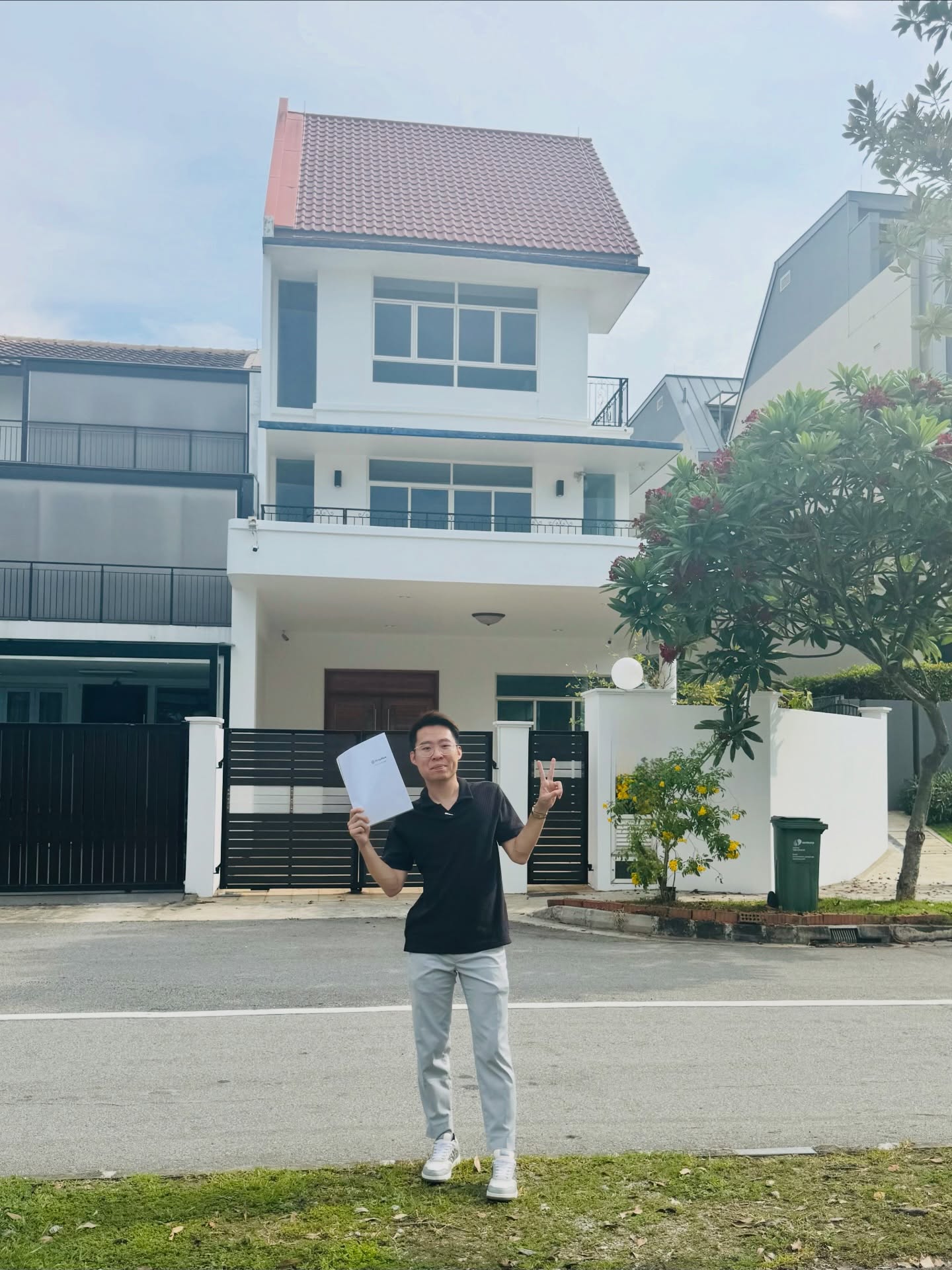 Nigel Aw in front of a landed home